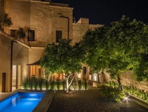 a swimming pool in front of a building at night at Palazzo Maresgallo Suites & SPA in Lecce