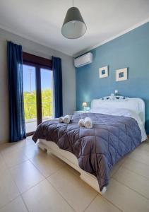 una camera da letto con un grande letto con pareti blu di 2-Bedroom, Sea-View Apartment - Balcony in Heaven! a Korakiaí