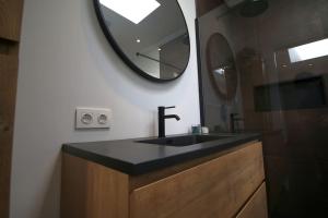 a bathroom with a sink and a mirror on the wall at Het Pareltje van Walsoorden in Walsoorden
