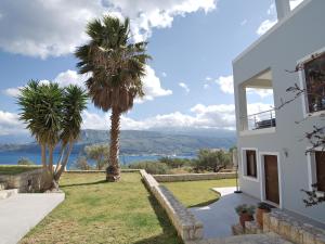 una casa bianca con palme e vista sull'acqua di 2-Bedroom, Sea-View Apartment - Balcony in Heaven! a Korakiaí