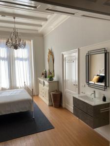 a bedroom with a bed and a sink and a mirror at Appartement Downtown in Haarlem