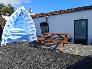 a picnic table and a bench next to a house at Casa do Cais in Monte