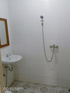uma casa de banho com um chuveiro e um lavatório. em Warung Rizka em Probolinggo