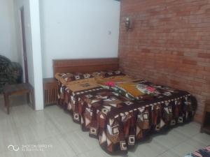 two beds sitting next to a brick wall at Warung Rizka in Probolinggo