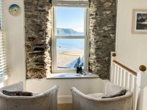 a room with two chairs and a window with a view of the ocean at Seaview in Gorran Haven