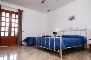een slaapkamer met 2 bedden met blauwe lakens bij Casa Enza di fronte la Tonnara in San Vito lo Capo