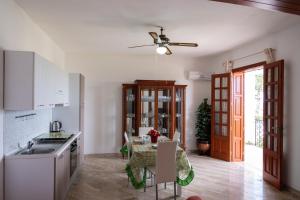 een keuken met een tafel en een plafondventilator bij Casa Enza di fronte la Tonnara in San Vito lo Capo