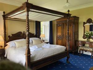 a bedroom with a canopy bed with towels on it at Blarcreen in Oban