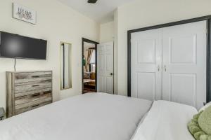 a bedroom with a white bed and a flat screen tv at Downtown Colorado Springs House in Colorado Springs