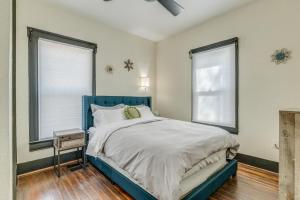 a bedroom with a blue bed and two windows at Downtown Colorado Springs House in Colorado Springs