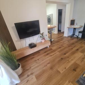 a living room with a flat screen tv and a wooden floor at ROYAL PARK -George in Eilat