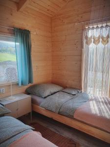 ein Schlafzimmer mit einem Bett in einer Holzhütte in der Unterkunft Domek Polna Cisza Bieszczady in Lesko