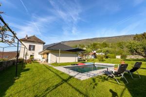 a yard with two chairs and a swimming pool at Charmante maison avec Vue LAC et Montagnes - PISCINE privative - LLA Selections by Location lac Annecy in Saint-Jorioz