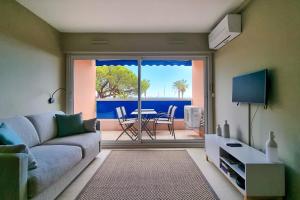 Apartment in Fréjus Plage by the seaside with direct access to the beach في فريجوس: غرفة معيشة مع أريكة وطاولة