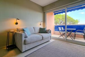 a living room with a couch and a large window at Apartment in Fréjus Plage by the seaside with direct access to the beach in Fréjus