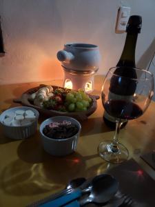 a table with a plate of food and a glass of wine at Chalé Sonho Diniz 2 in Monte Verde