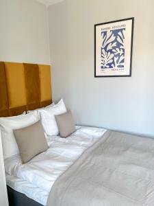 uma cama branca com duas almofadas em cima em Studio Apartment Station em Oulu