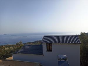 Raches的住宿－Aloni Cottage above Aegean Sea，一座白色的小建筑,上面有标志