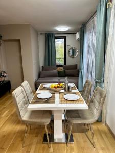 a dining room with a table and chairs and a couch at Vitosha Terrace 1BR Apartment with Parking in Sofia