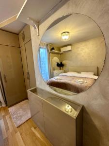 a bedroom with a large circular mirror on the wall at Vitosha Terrace 1BR Apartment with Parking in Sofia