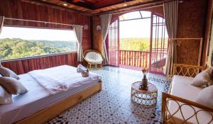 a bedroom with a bed and a balcony with two windows at Auguri Homestay Mang Den in Kon Von Kla