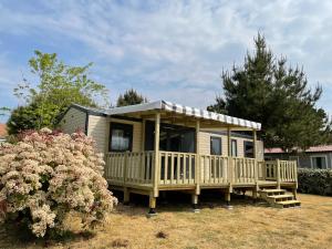 een tiny house met een veranda en een terras bij Camping Le Village de la Mer in Les Moutiers