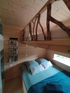 a bedroom with a bed in a wooden cabin at La roulotte de Jane in Margon