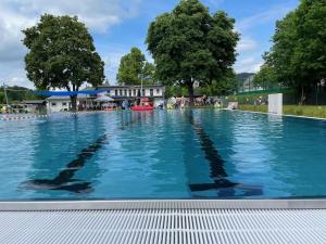 een groot zwembad met blauw water bij Ols Berghaus in Olsberg