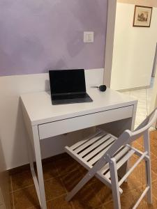 een laptop op een wit bureau met een stoel bij Comodo alloggio in Beinette - Casa Allegri in Beinette