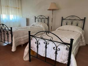 a bedroom with two beds with white sheets at Appartamento Gardenia in Nardò