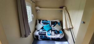a bedroom with a bed with blue and white pillows at Mobil Home O'HARA Confort Plus Parc Saint James Montana in Gassin