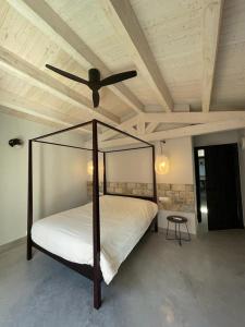 a bedroom with a canopy bed with a ceiling fan at Casa Palma Pals 2 in Pals