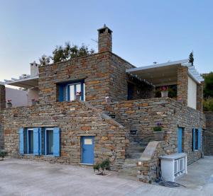 a brick house with a blue door and windows at Charming Vourkari Stone Home 1 - Minutes from port in Vourkari