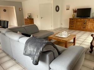 a living room with a gray couch and a table at Ferienhaus Mone in Monschau