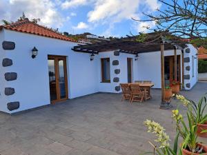 un patio di una casa bianca con tavolo in legno di Casa Amagante, en Hoyo de Mazo a Mazo