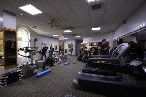 a gym with cardio equipment and a man working out at Glenavon House Hotel in Cookstown