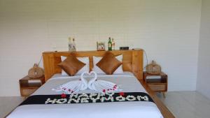 a bedroom with a bed with two swans on it at Mahadanu Kintamani Private Villa in Kintamani