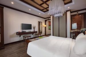 een slaapkamer met een groot wit bed en een bureau bij EBINO PULUONG RESORT in Pu Luong