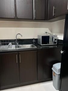 a kitchen with a sink and a microwave at 2-Bedroom Manhattan, Cubao Condo in Manila