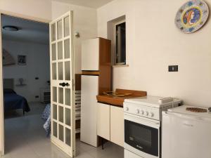 a kitchen with a stove and a refrigerator at Home Vivaldi in Castellammare del Golfo