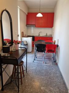 a kitchen with red cabinets and a table and chairs at ComeHome in Heraklio Town