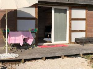 stół i parasol na drewnianym tarasie w obiekcie Chalet bois cosy avec piscine Aix nature w Aix-en-Provence