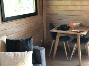 a small table and chairs in a room with a window at Chalet bois cosy avec piscine Aix nature in Aix-en-Provence