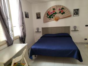 a bedroom with a blue bed and a window at Home Vivaldi in Castellammare del Golfo