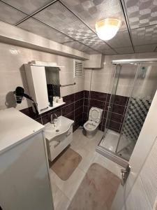 een badkamer met een douche, een toilet en een wastafel bij Akhome - Luxury dublex apartment in Canakkale