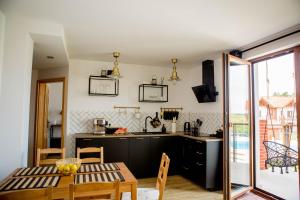 a kitchen and dining room with a table and chairs at Apartament Może Morze Łebska Ostoja in Żarnowska