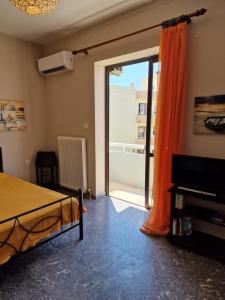 a bedroom with a bed and a sliding glass door at ComeHome in Heraklio Town