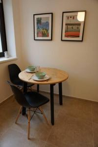 a wooden table with two bowls and two chairs at Central City Apartment in Hanover in Hannover