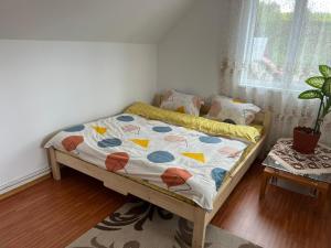 a bedroom with a bed with a quilt on it at Casa Nico in Sărmaş