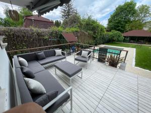 een terras met een bank en stoelen bij 5 bedroom villa very close to Balaton in Balatonkenese